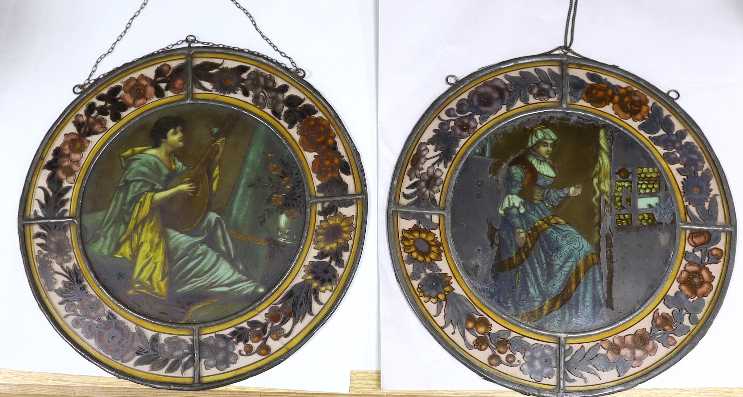 Two Victorian stained glass leaded roundels, one depicting a gentleman playing a lute, 32cm in diameter